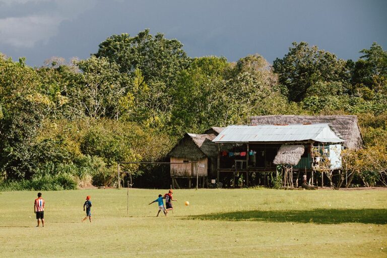 Children playing soccer in a village