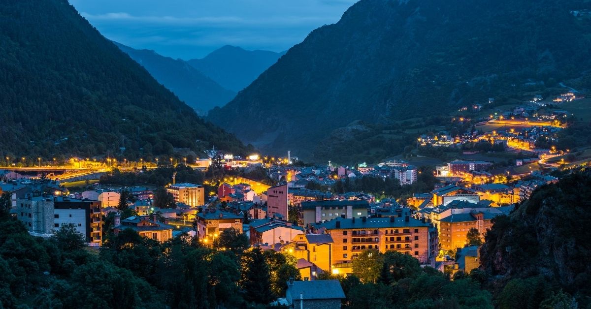 Andorra la Vella valley at dusk with colorful lights and buildings surrounded by mountains