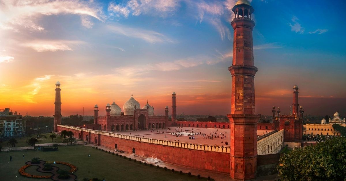 panoramic view of beautiful red mosque and fort at dusk with dramatic skies