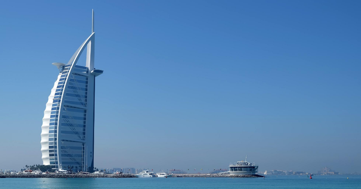 sail shaped hotel in at water's edge with boats in Dubai
