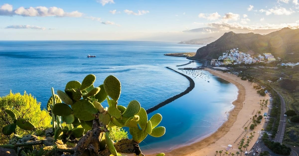 view down to the coastal Santa Cruz de Tenerife in the Canary Islands with mountains, town and beach