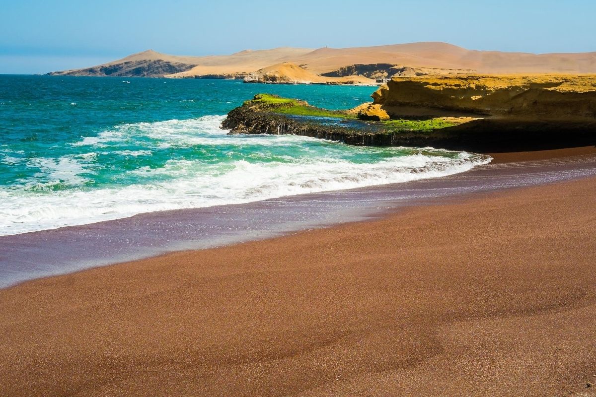 red sand beach with surrounding desert and Pacific ocean in Paracas, Peru