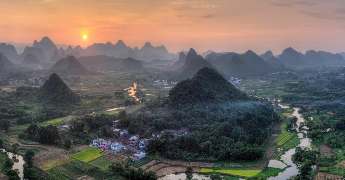 bird's eye view of sunset over Yulong Valley surrounded by karsts and river tributaries