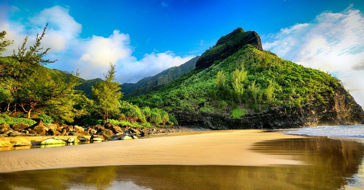 Hawaiian Islands with lush beach landscapes like this mountain on the Nā Pali coast on Kauai