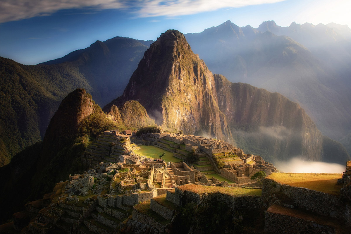 Machu Picchu at sunrise with misty clouds rolling through