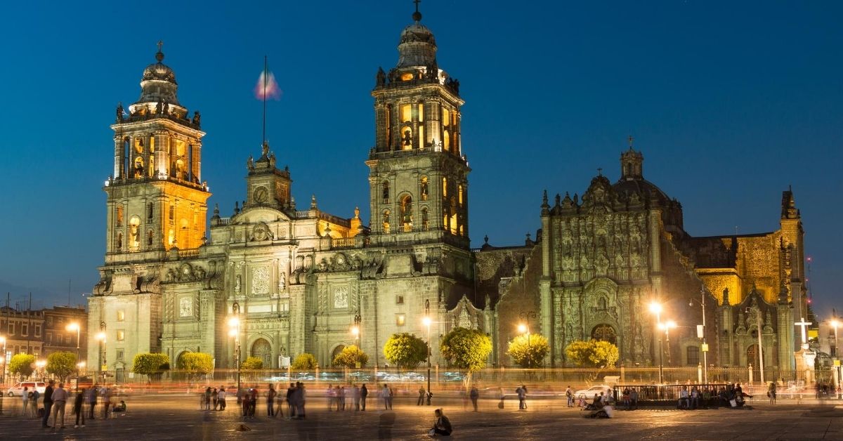 The Metropolitan Cathedral with its spanish colonial architecture in Mexico City at night with people in square