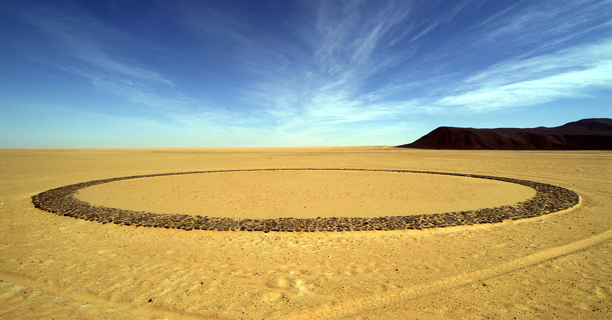 the barren Tenere Desert with mysterious stone circles and mountain in Niger