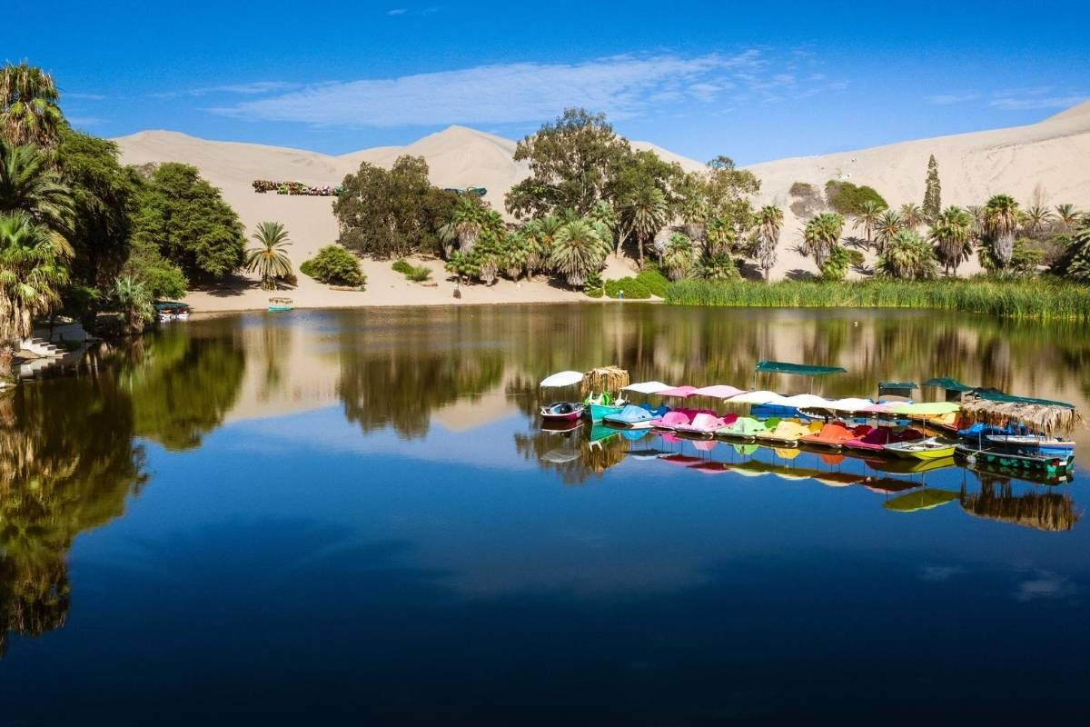 an oasis in the desert at Huacachina with colorfol paddle boats