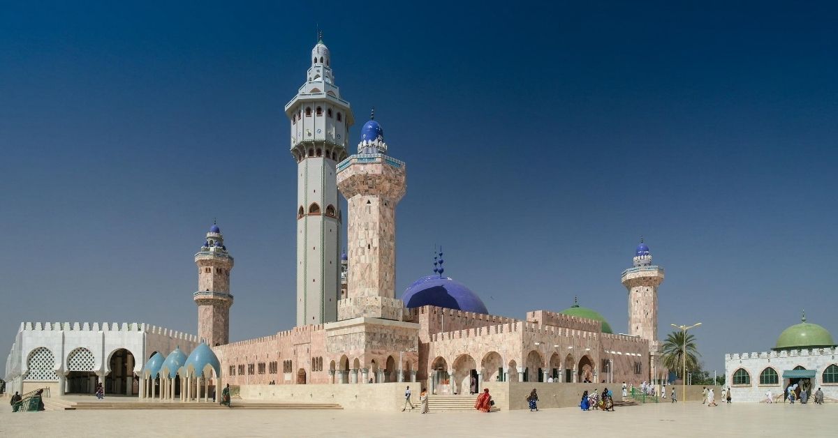 colorful mosque complex in Mouridism, Senegal with people walking around