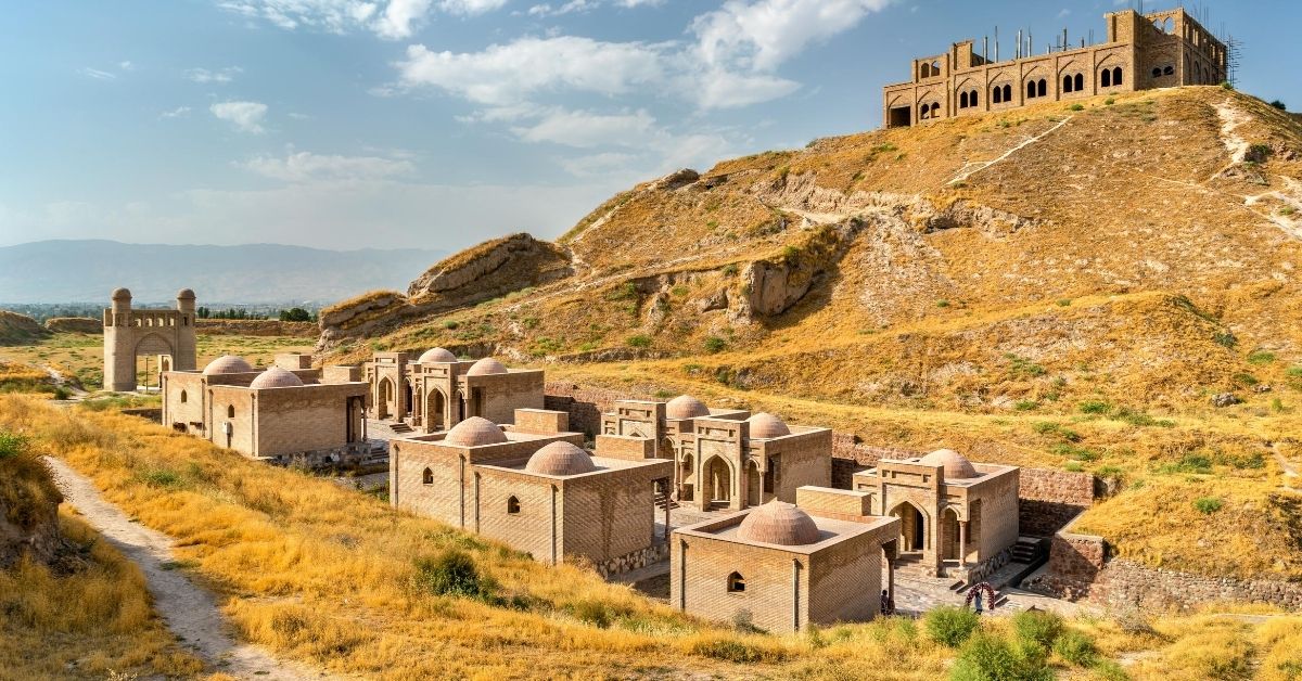 historical fortress on a hill with dry landscape and buildings below