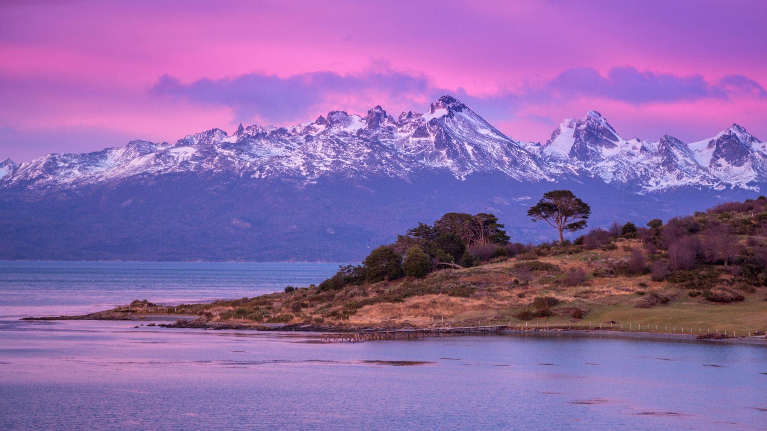 mountains and lake with a dramatic pink and purple sky