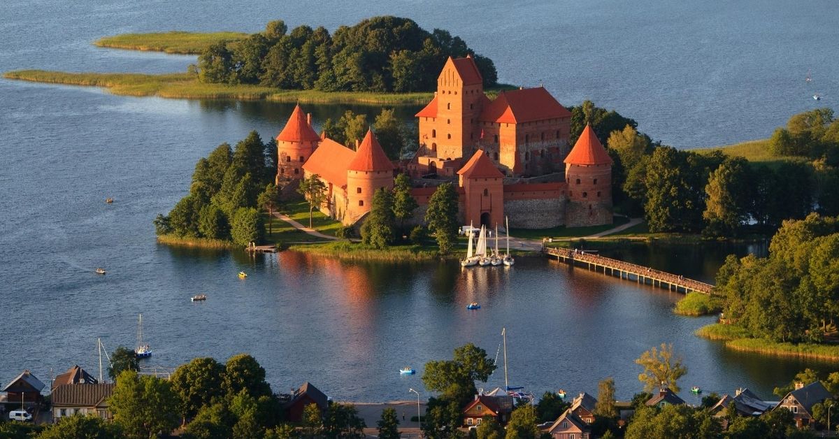 castle in lake with boats and village