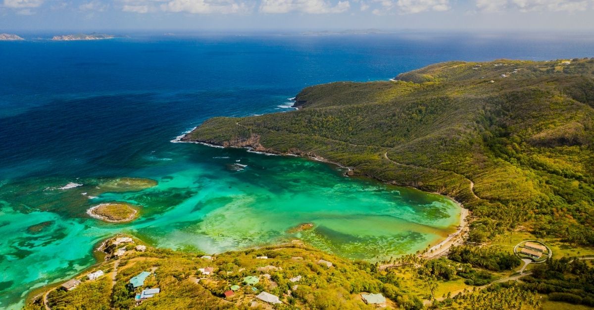 bird's eye view of small cove with beautiful Caribbean waters in shades of blue to green