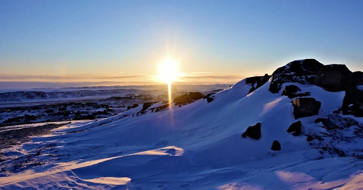 sun shining down on snow covered mountains in the Canadian Arctic