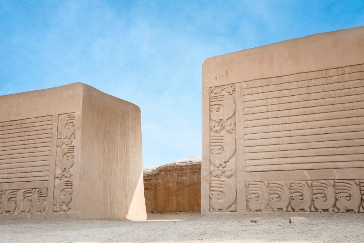 giant walls against a blue sky in ancient Chan Chan in Peru