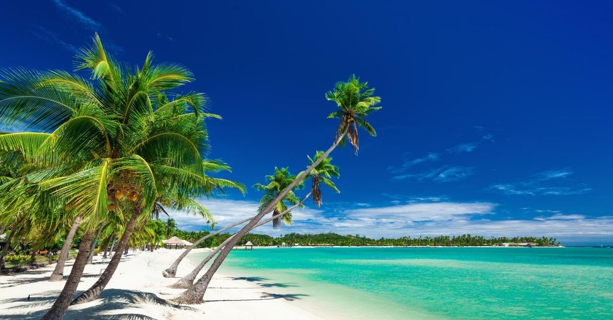 white sand beach, turquoise water and bures in Fiji