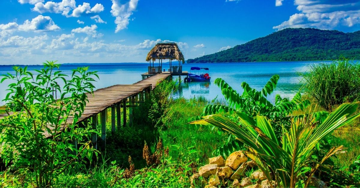 beautiful landscape with pier, boat and volcanot at Lake Peten in Guatemala