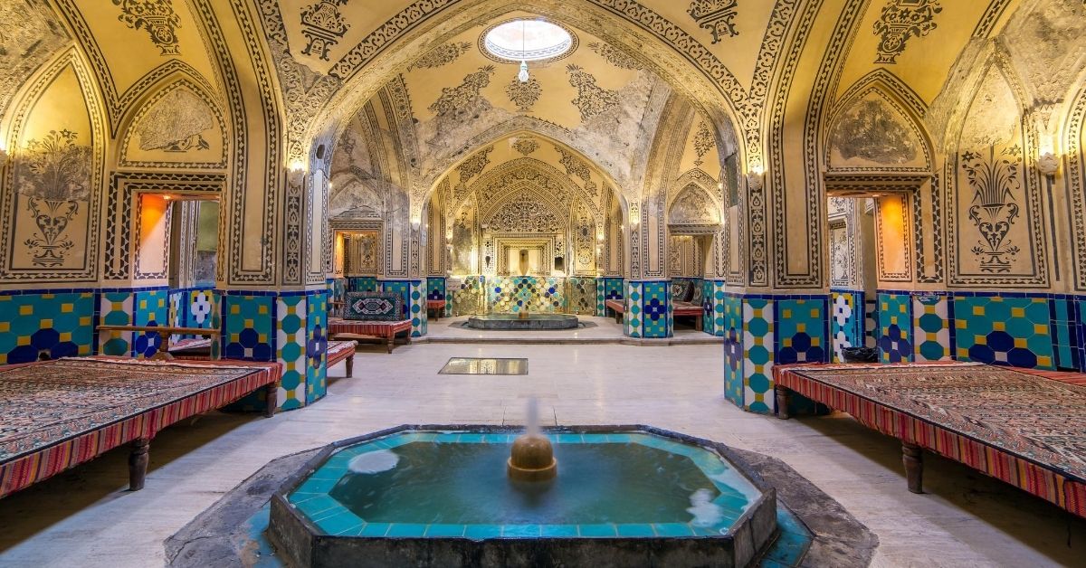 ornate historic bath house with domed ceilings, fountains, tiles and mosaics