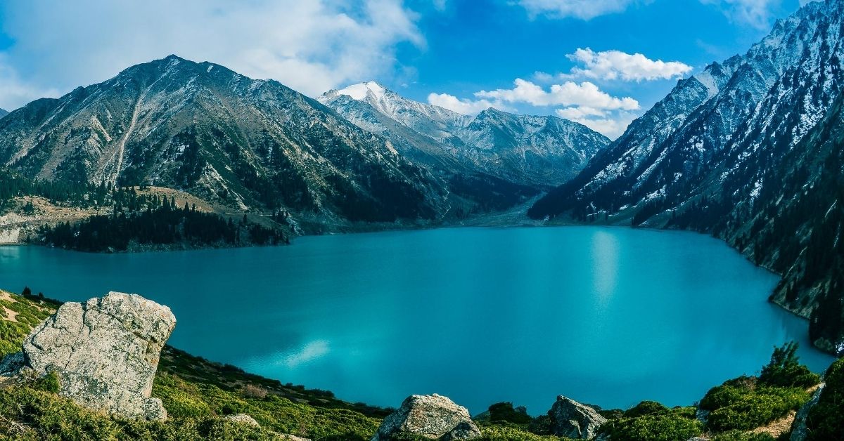 Turquoise colored waters of Big Almaty Lake surrounded by mountains in Kazakhstan