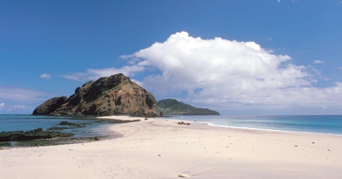 a peninsula with beach and mountains and the Indian Ocean on both sides with blue skies and clouds in Mayotte