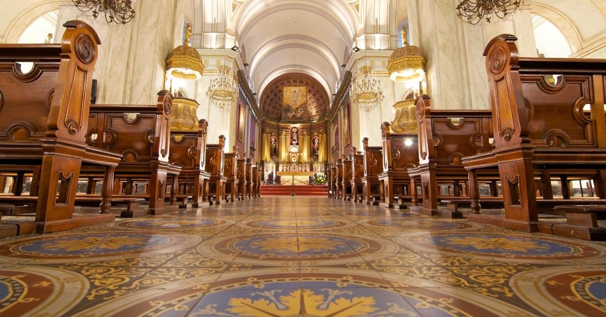 interior with gold and blue tiles and ornate wooden pews