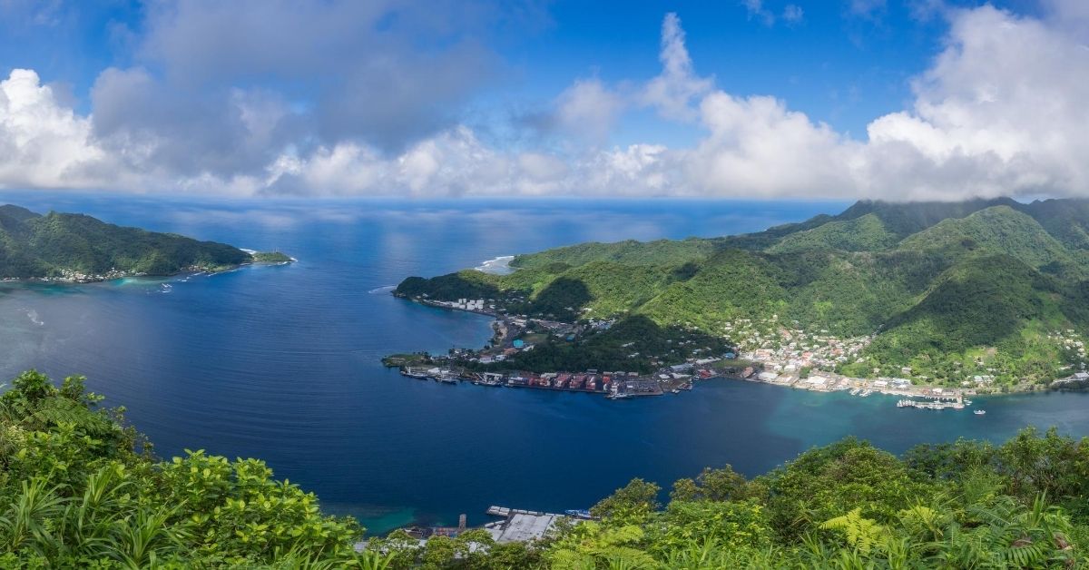 aerial view of mountainous island and town with bay and Pacific ocean