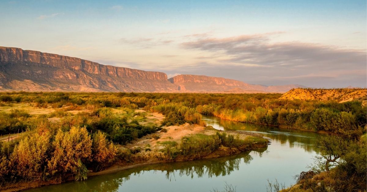 golden landscape with buttes and the Rio Grande river in the early morning