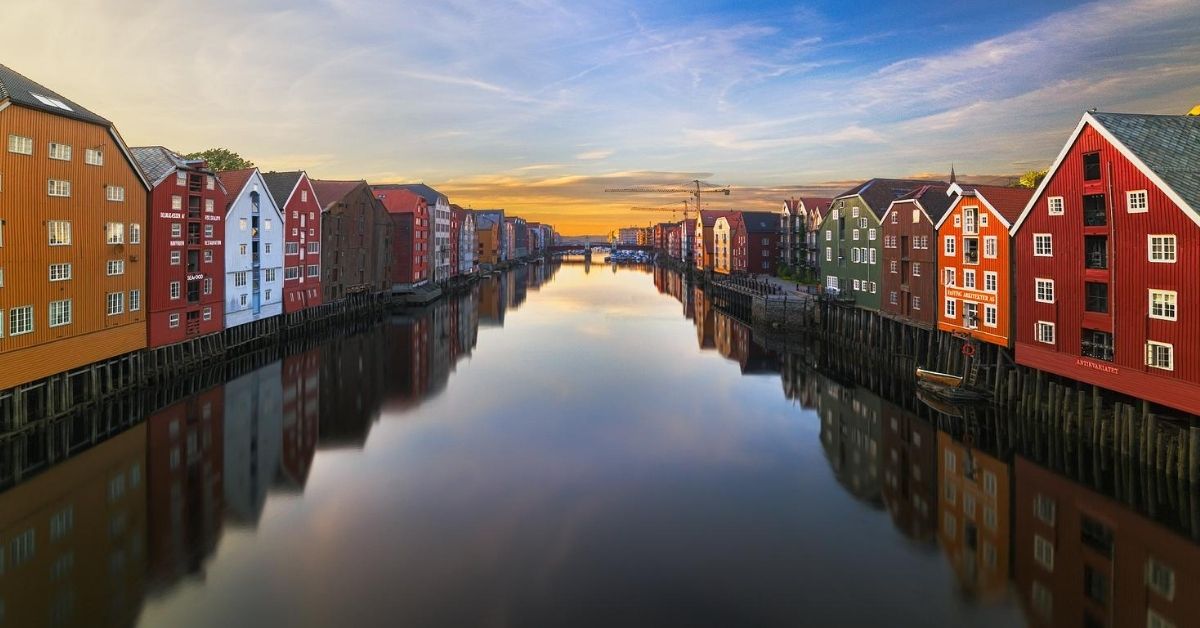 river with colorful houses on either side at dusk in Trondheim, Norway